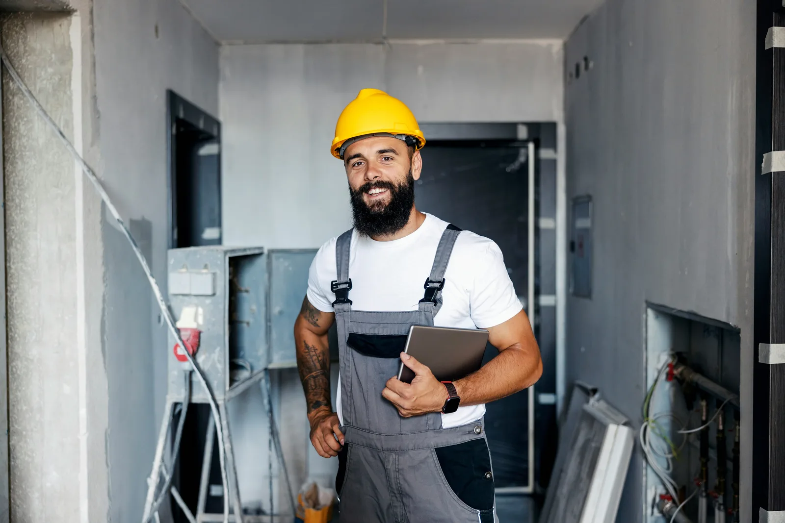 Electrician reviewing a job on a tablet at a job site